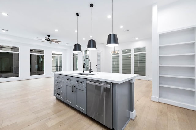 kitchen featuring pendant lighting, sink, a kitchen island with sink, gray cabinetry, and stainless steel dishwasher