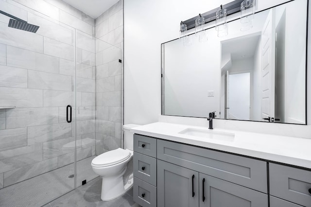 bathroom with vanity, a shower with door, and toilet