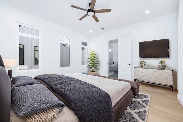 bedroom featuring connected bathroom, light hardwood / wood-style flooring, and ceiling fan