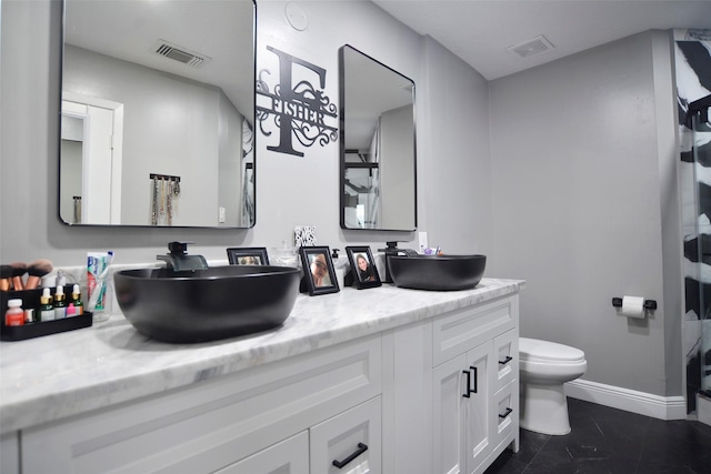 bathroom with tile patterned flooring, vanity, and toilet