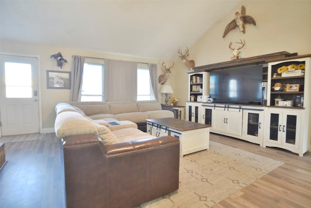 living room with light hardwood / wood-style flooring and vaulted ceiling