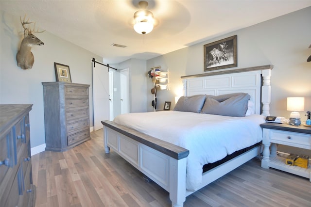 bedroom featuring dark hardwood / wood-style floors and a barn door