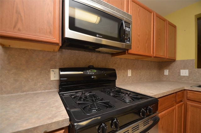 kitchen with tasteful backsplash and gas stove