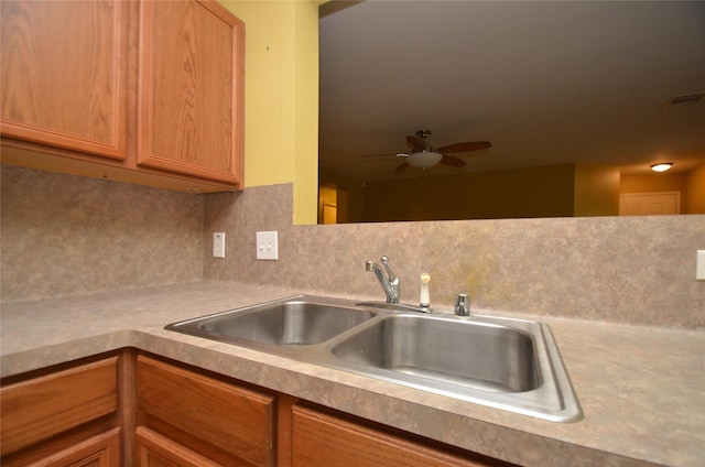 kitchen featuring ceiling fan, sink, and decorative backsplash