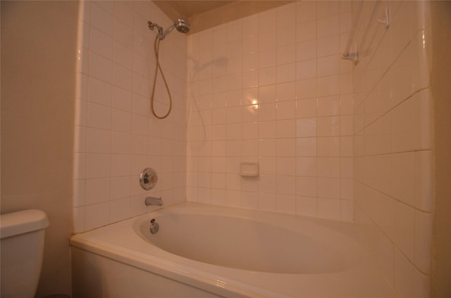 bathroom featuring tiled shower / bath and toilet