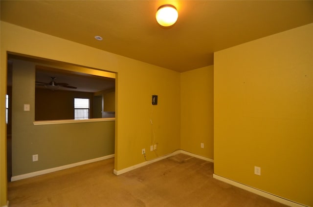 carpeted spare room featuring ceiling fan