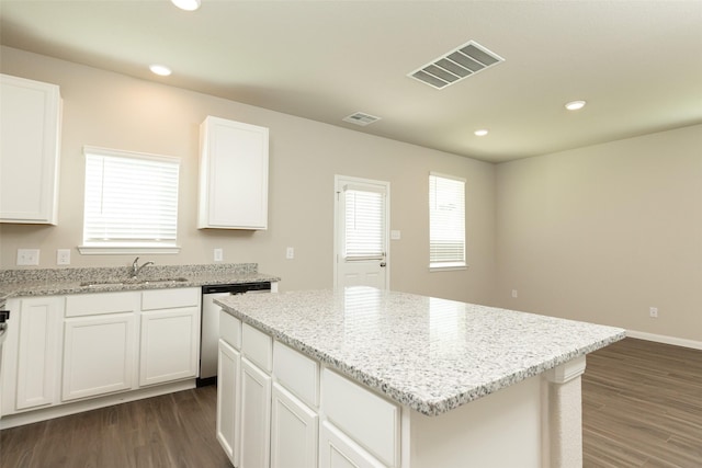 kitchen with dark hardwood / wood-style floors, white cabinetry, dishwasher, sink, and a center island