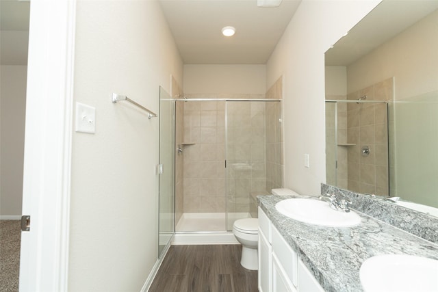 bathroom featuring an enclosed shower, wood-type flooring, vanity, and toilet