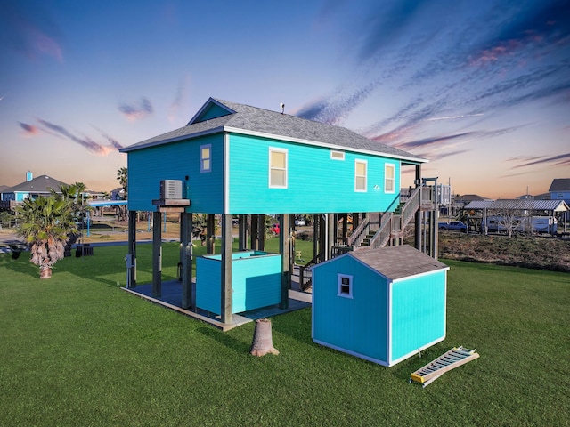 playground at dusk with a lawn and an outdoor structure