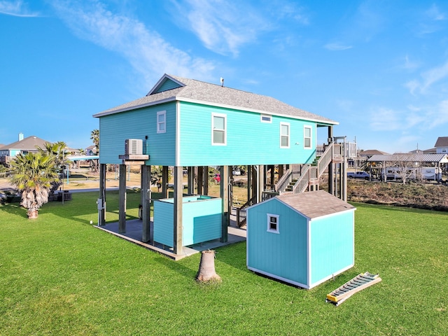 back of house featuring a storage shed and a lawn