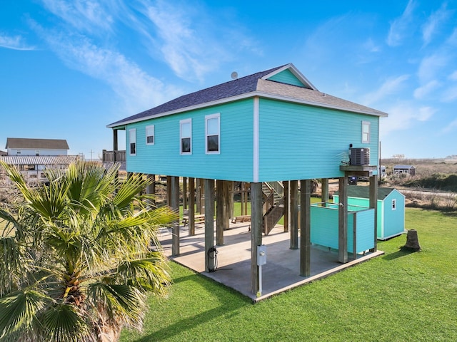 back of house with a carport, cooling unit, a lawn, and a patio area