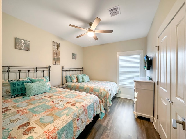 bedroom featuring dark wood-type flooring, ceiling fan, and a closet