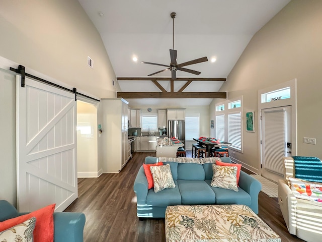 living room featuring sink, a barn door, vaulted ceiling, and a wealth of natural light