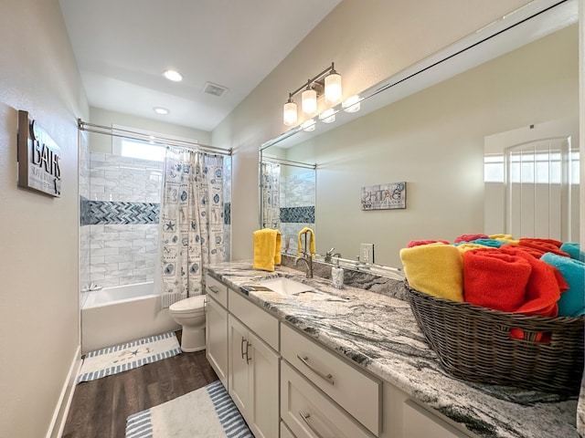 full bathroom featuring wood-type flooring, toilet, vanity, and shower / bath combo