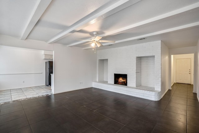 unfurnished living room featuring a brick fireplace, beamed ceiling, and ceiling fan