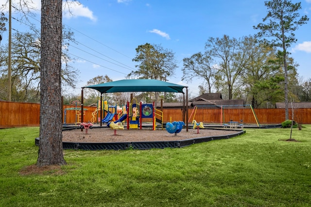 community play area featuring a yard and fence