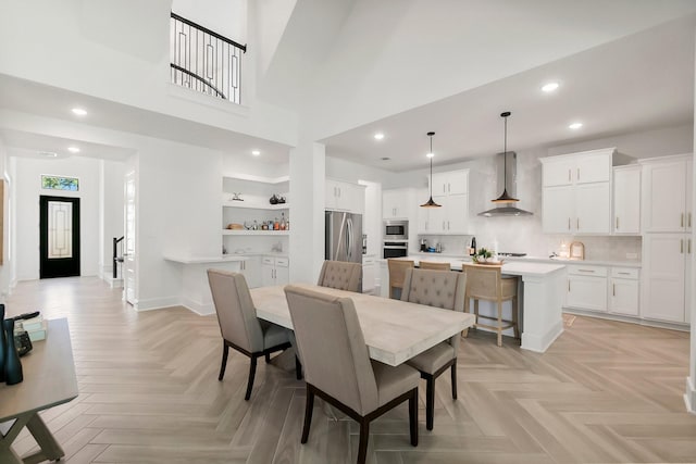 dining room with light parquet floors and a high ceiling