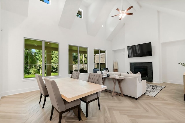 dining area featuring beamed ceiling, light parquet flooring, a towering ceiling, and ceiling fan