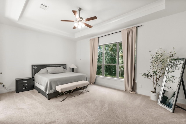 bedroom featuring a raised ceiling, carpet floors, and ceiling fan