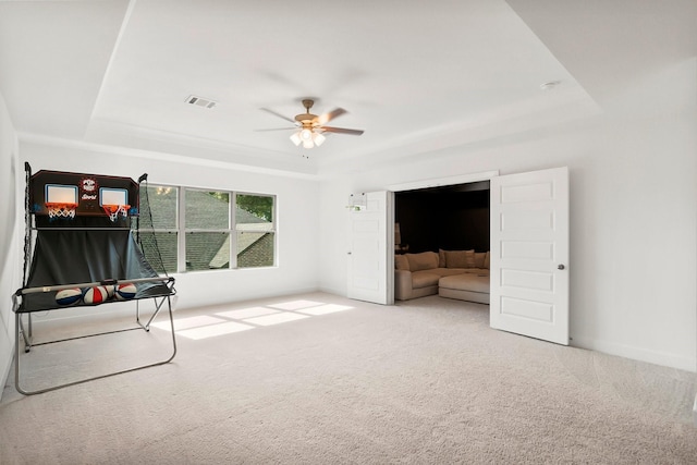 interior space featuring carpet flooring, ceiling fan, and a tray ceiling