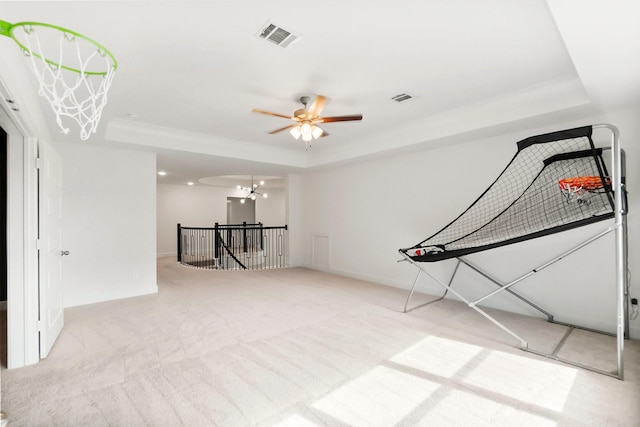 interior space featuring light carpet, a tray ceiling, and ceiling fan