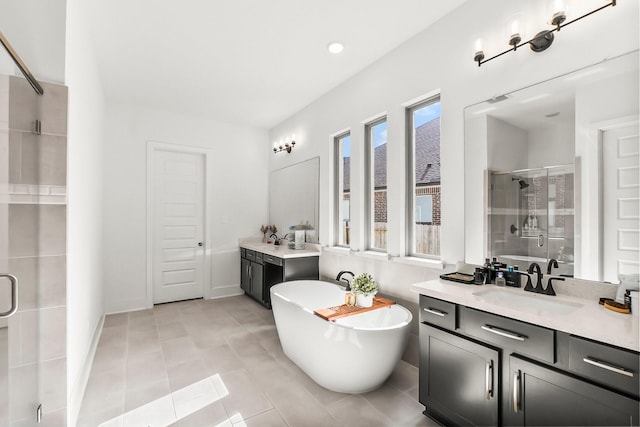 bathroom with plus walk in shower, vanity, and tile patterned floors