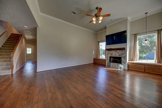 2106 Springwood, Brenham, TX 77833 - unfurnished living room with ceiling fan, a tile fireplace, stairway, dark wood finished floors, and crown molding