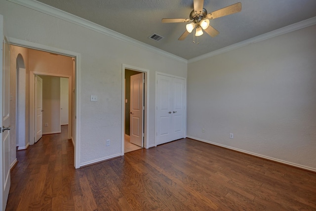 2106 Springwood, Brenham, TX 77833 - unfurnished bedroom featuring dark wood-style flooring, ornamental molding, baseboards, arched walkways, and a ceiling fan