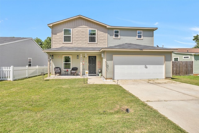 front of property with a garage, a front lawn, and covered porch