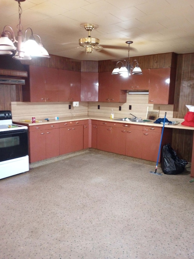 kitchen with electric stove, sink, pendant lighting, ventilation hood, and ceiling fan with notable chandelier