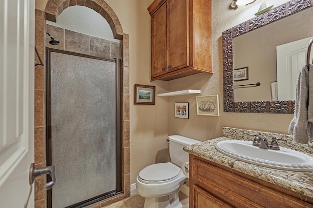 bathroom featuring vanity, toilet, and a shower with door