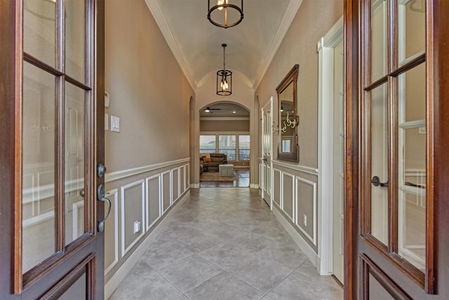 corridor with crown molding and light tile patterned floors