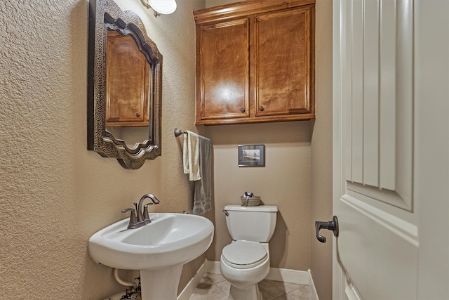 bathroom featuring sink, toilet, and tile patterned flooring