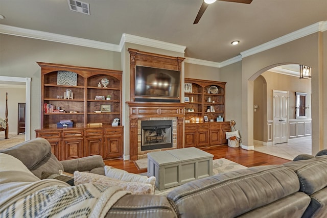 living room featuring crown molding, ceiling fan, and light hardwood / wood-style flooring