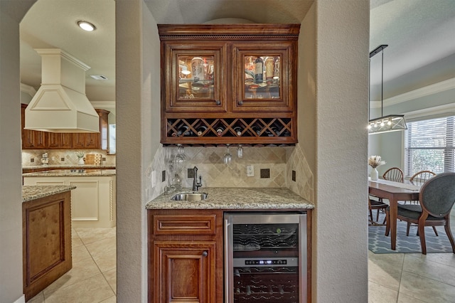 bar featuring sink, backsplash, custom exhaust hood, and beverage cooler