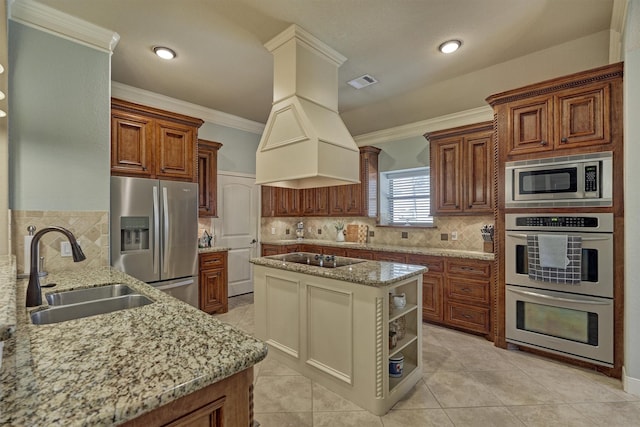 kitchen with sink, backsplash, custom exhaust hood, stainless steel appliances, and light stone countertops