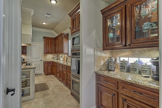 kitchen featuring crown molding, decorative backsplash, appliances with stainless steel finishes, and light tile patterned flooring