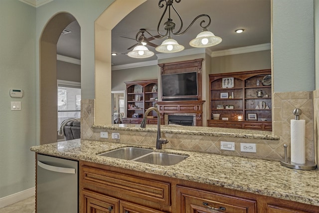 kitchen featuring sink, ornamental molding, stainless steel dishwasher, light tile patterned floors, and light stone counters