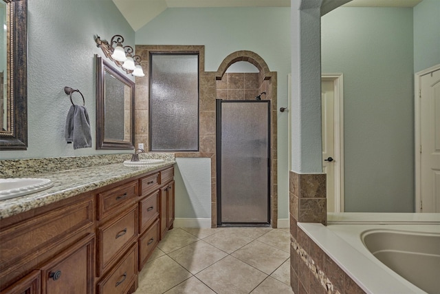 bathroom with lofted ceiling, tile patterned floors, separate shower and tub, tile walls, and vanity