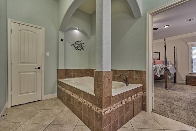 bathroom featuring crown molding, tiled bath, and tile patterned flooring