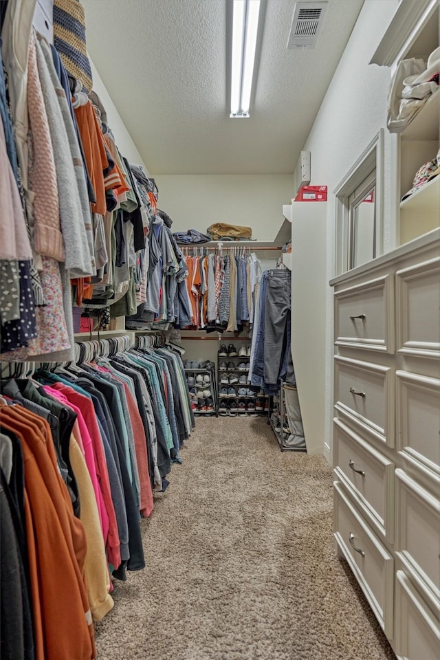 walk in closet with carpet floors