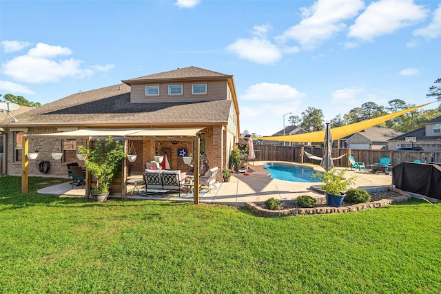 rear view of property featuring a fenced in pool, an outdoor living space with a fireplace, a yard, and a patio area