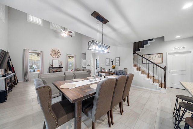 dining space with ceiling fan and a towering ceiling