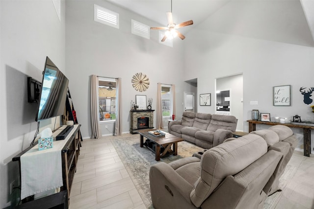 living room with ceiling fan and a stone fireplace