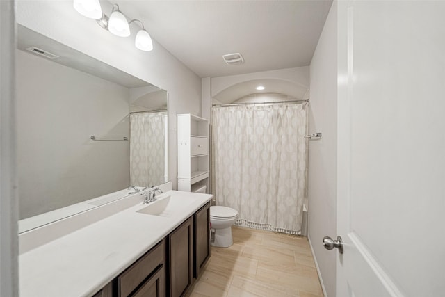 full bathroom featuring shower / bath combination with curtain, vanity, and toilet