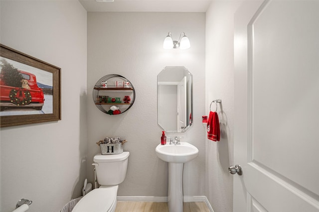 bathroom with hardwood / wood-style flooring and toilet