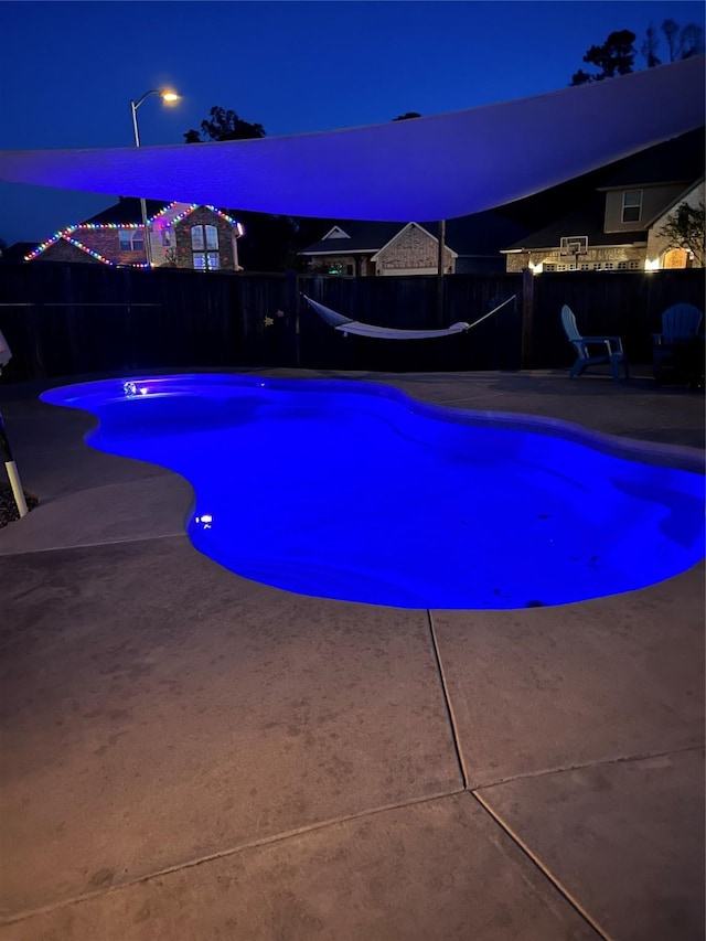 pool at twilight with a patio