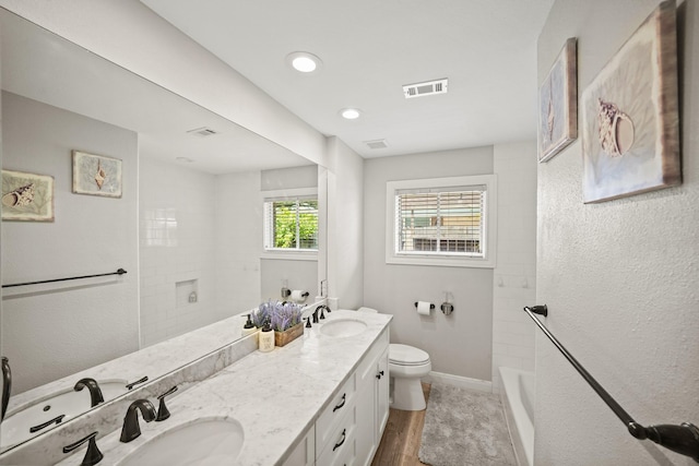 bathroom with vanity, wood-type flooring, toilet, and a tile shower