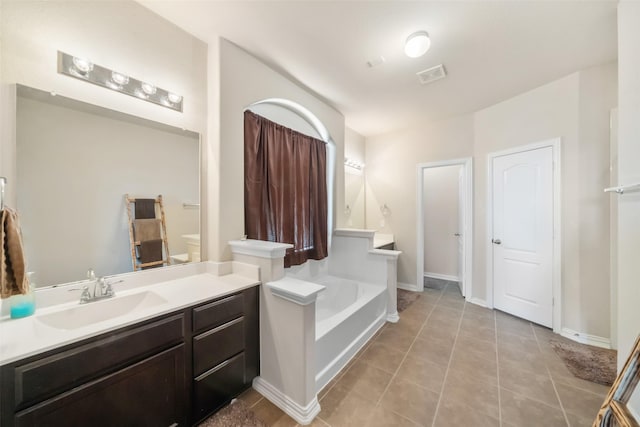 bathroom featuring tile patterned flooring, vanity, and a washtub