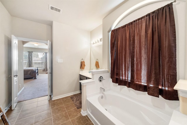 bathroom featuring tile patterned flooring, vanity, and a tub to relax in